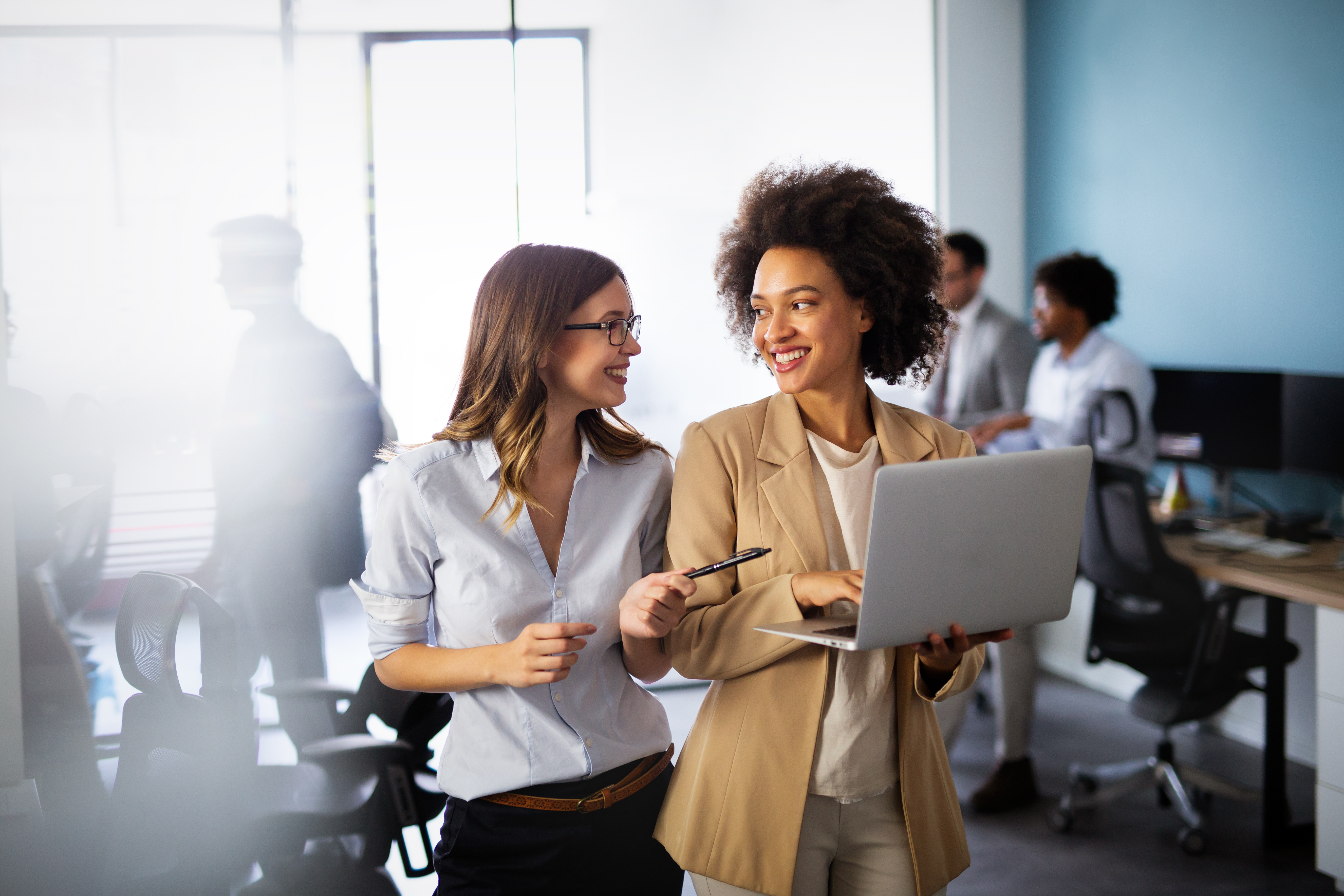 A imagem mostra 2 mulheres andando pelo escritório
